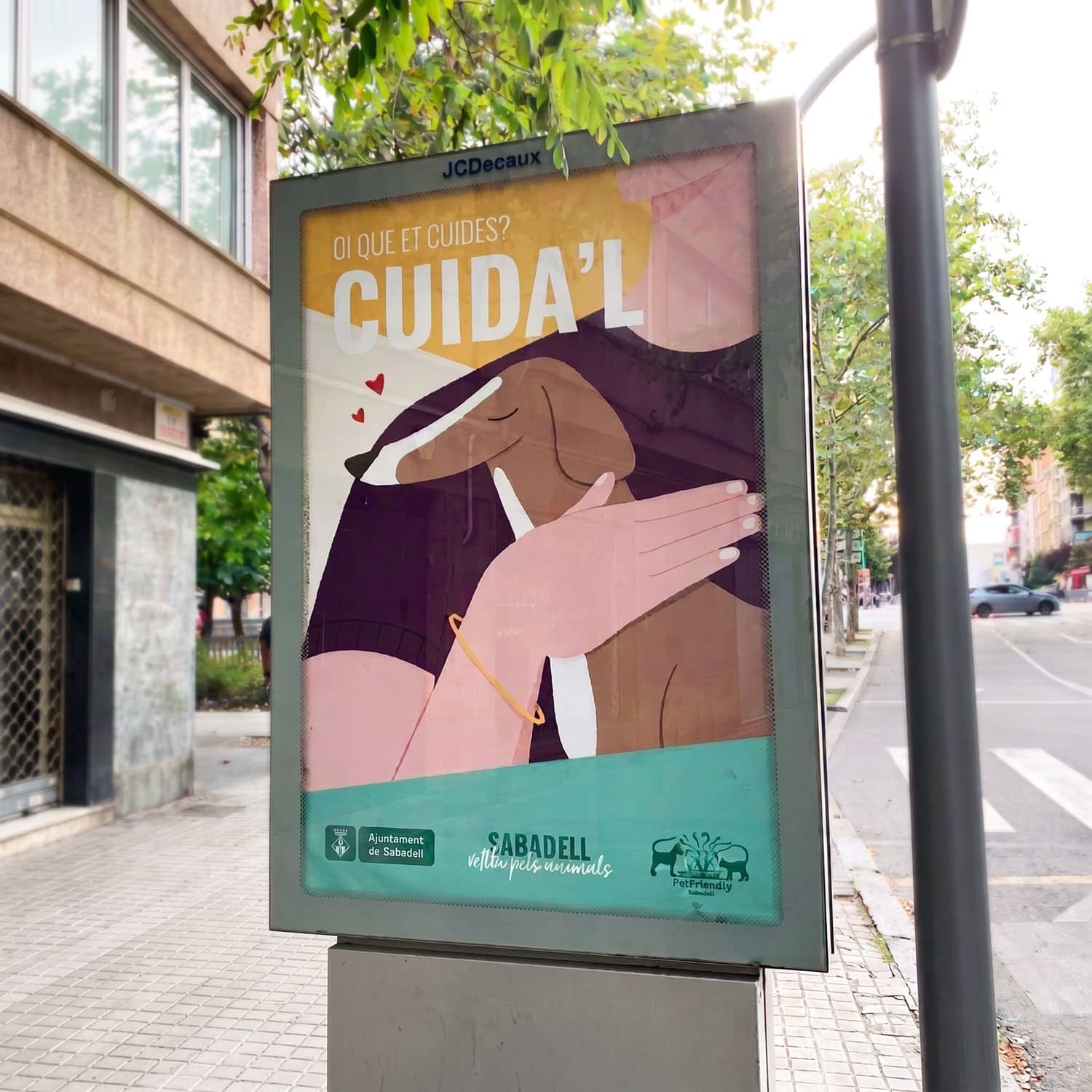 A poster promoting animal care in Sabadell, featuring a person holding a dog with a heart illustration.