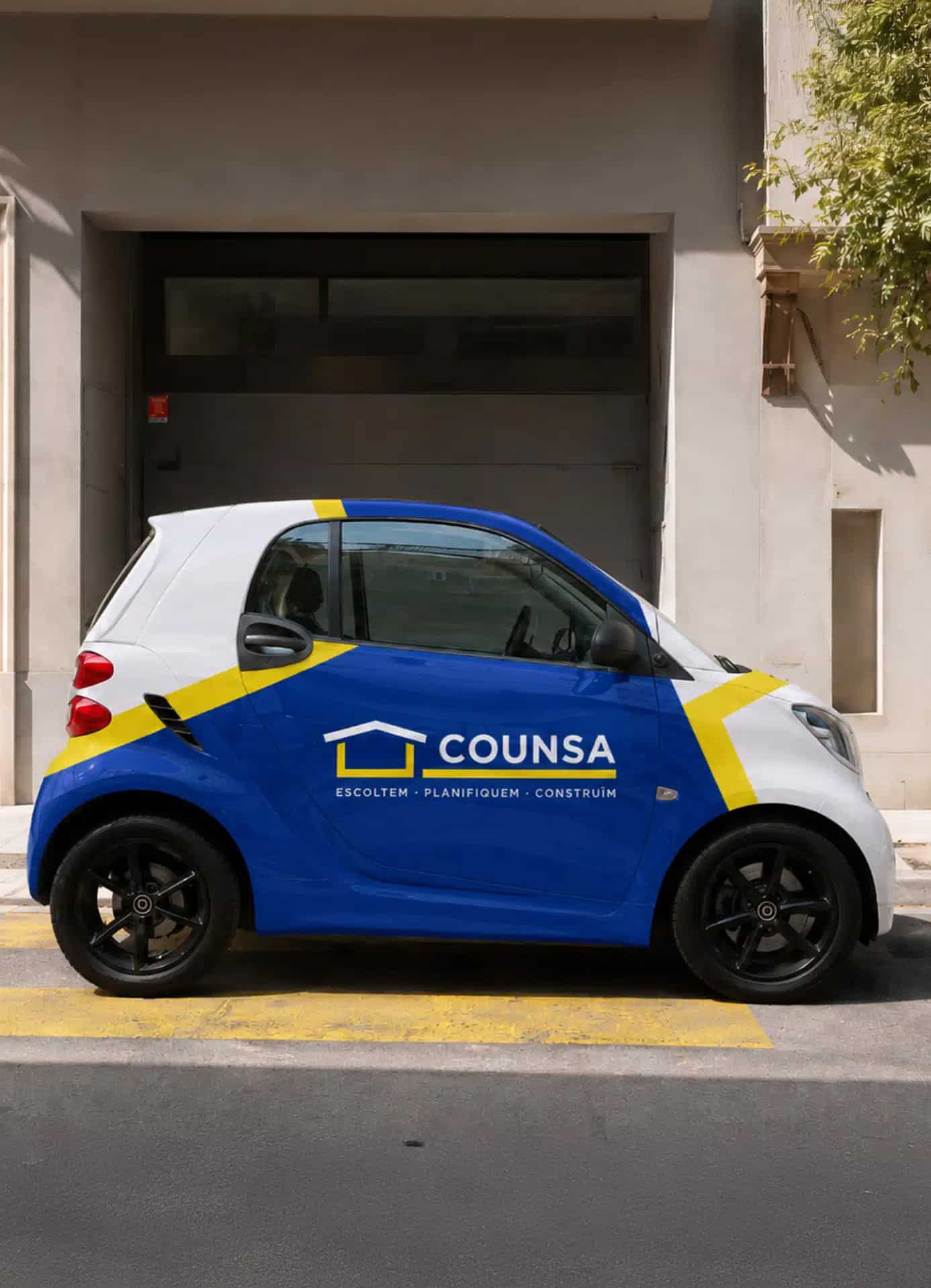 Coche pequeño con publicidad de Counsa estacionado frente a una puerta gris.
